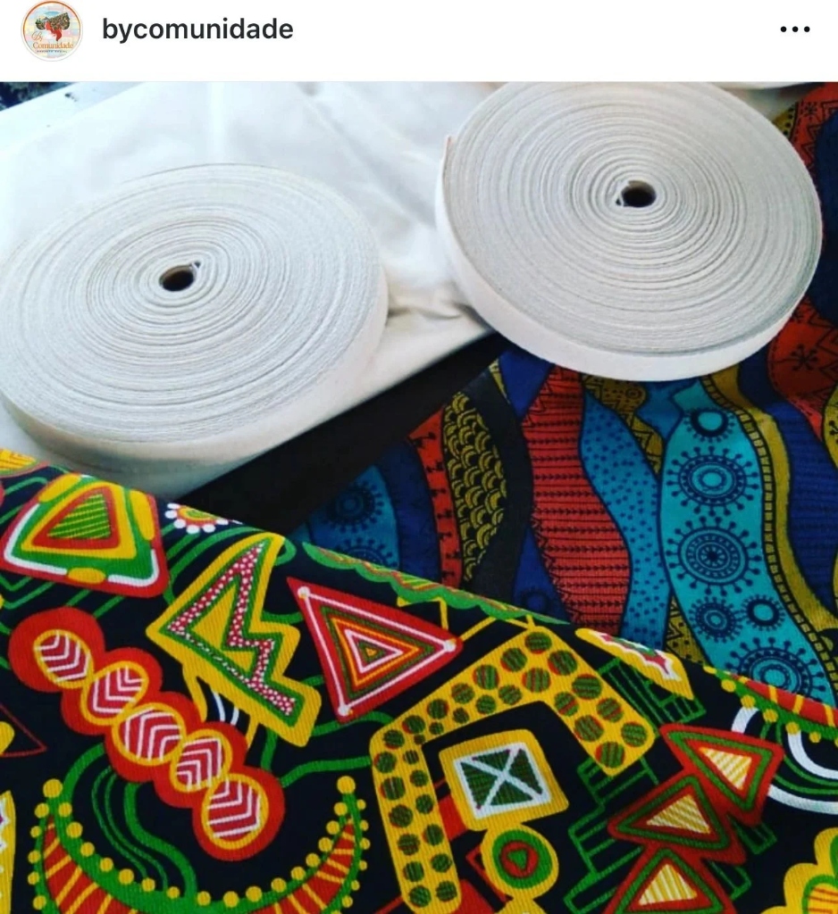 Colorful African fabric with white fabric rolls, showcasing traditional artisan craftsmanship.